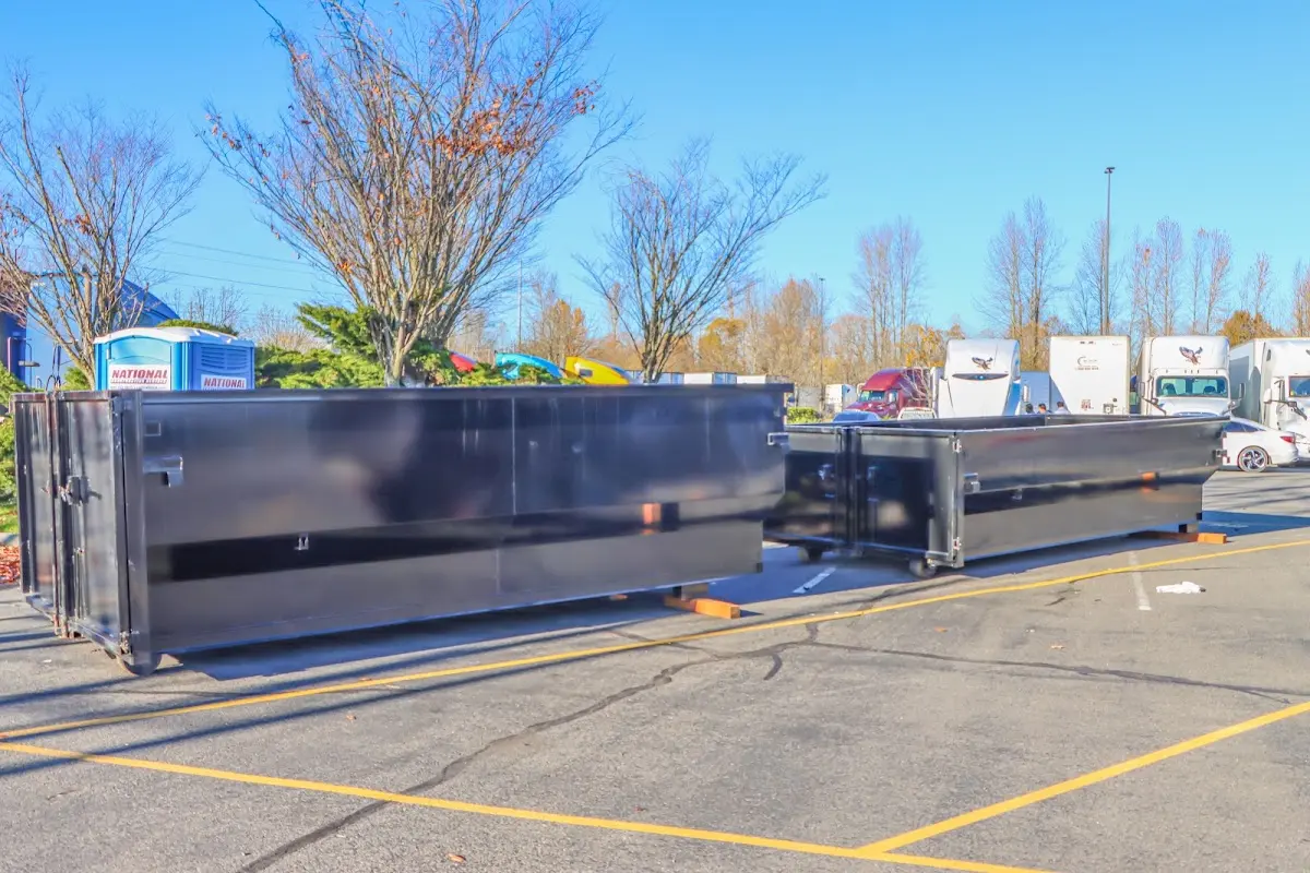 Professional dumpster rental service with roll-off container on residential driveway in Marquette